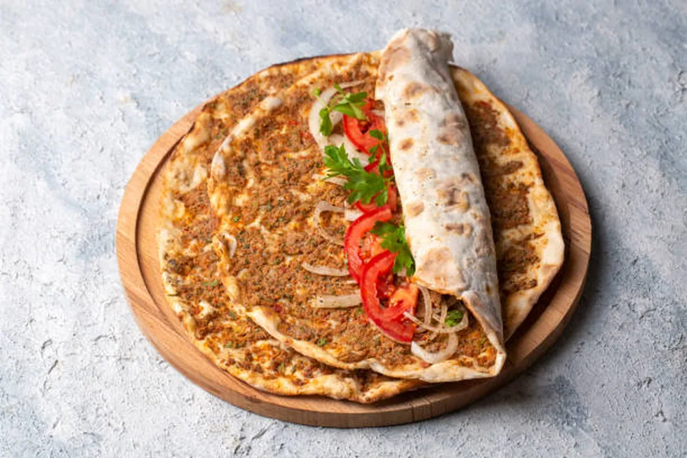 Maydanoz, domates ve soğanla sunulan ince Şanlıurfa lahmacunu