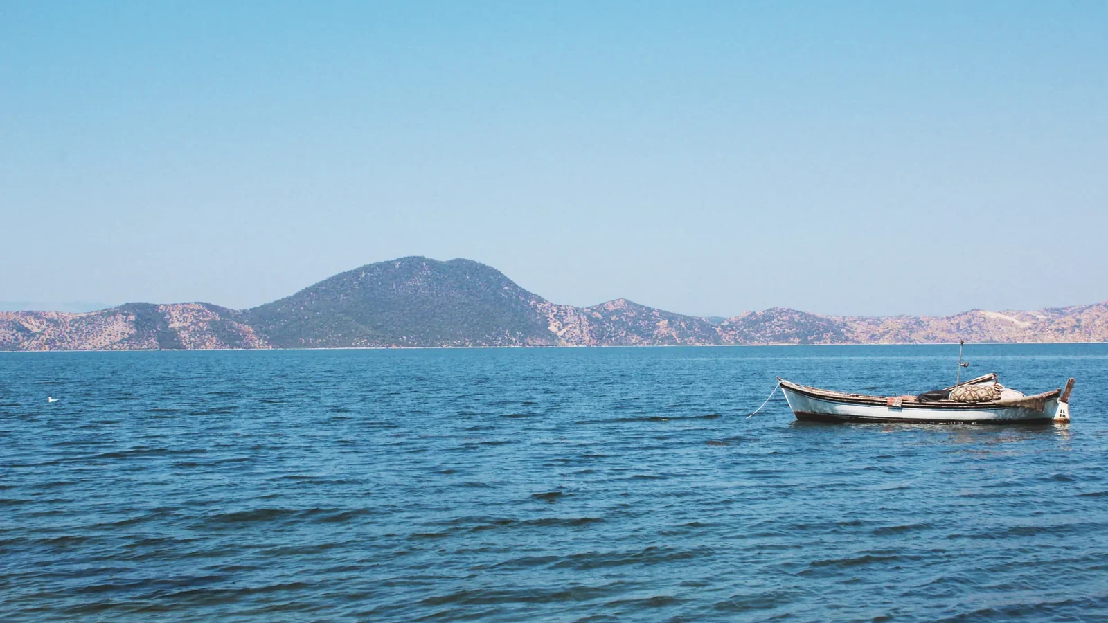 Bafa Gölü üzerinde kayık ve dağ manzarası