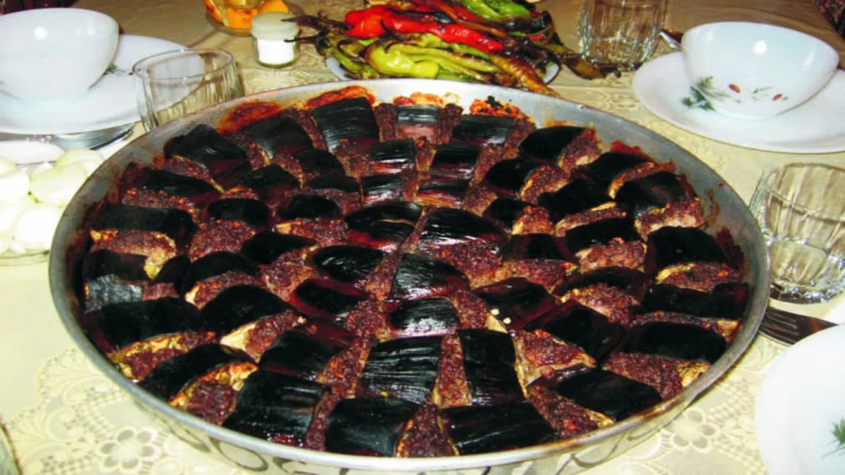 Yuvarlak tepside patlıcan ve kıymayla hazırlanmış Şanlıurfa tepsi kebabı